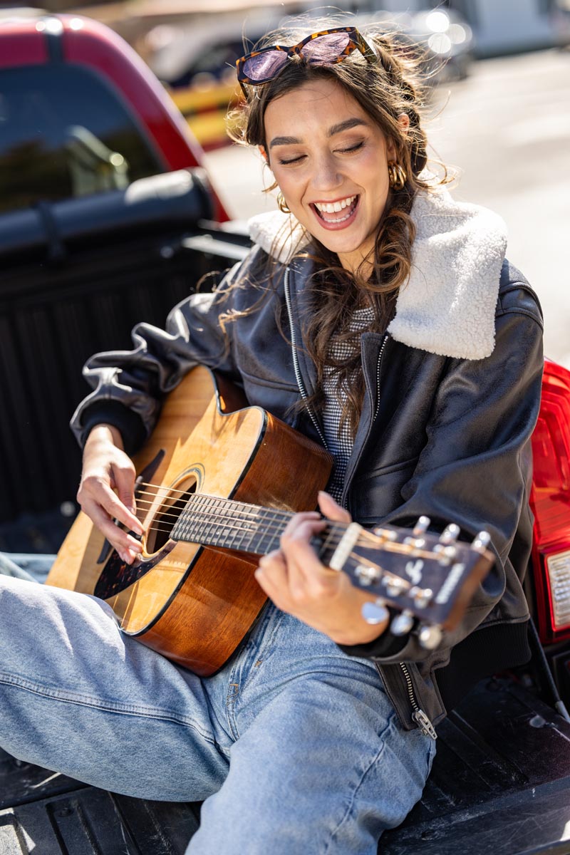 girl sitting playing guitar